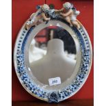 An early 20th century Continental porcelain oval mirror,