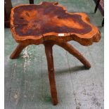 An unusual rustic yew wood cricket table, the shaped top formed from a transverse section,