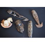An African carved softwood mask, two others similar; a similar figure; a stoneware money box,
