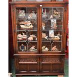 An oak Old Charm display cabinet, moulded cornice above a pair of glazed and leaded doors,
