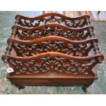A Victorian walnut Canterbury, shaped and pierced dividers, turned legs, ceramic casters,