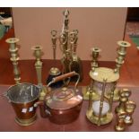 A Victorian copper kettle; a set of three brass bell weights; two pairs of brass candlesticks;