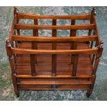 A 20th century mahogany three section Canterbury, drawer to frieze, turned finials, casters,