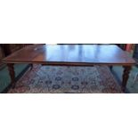 A 19th century mahogany extending dining table, associated leaves, turned tulip carved legs,