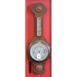 An oak framed carved aneroid barometer thermometer, carved top and foot, silvered scale,