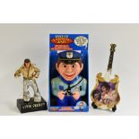 A novelty Elvis Presley figural radio; an Elvis ceramic guitar,