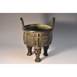 A Chinese dark patinated ding tripod censer, in the Archaic taste, lug handles, characters to base,