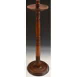 A 19th century mahogany floor standing candlestick, dished wax pan, ring-turned sconce and column,