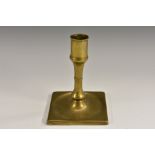 A George I/II brass candlestick, of seamed construction and short proportions, dished square base,