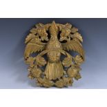 A 19th century Indian gilded hardwood carving, depicting a bird holding a branch, 34cm high,