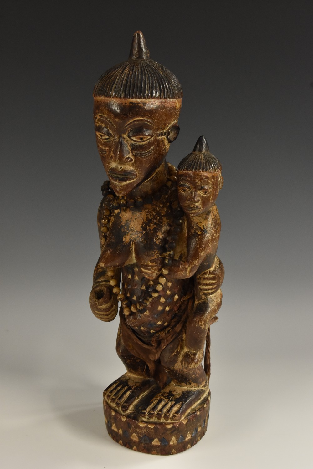 Tribal Art - an African fertility figure, she stands, holding an infant,