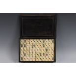 A Chinese mahjong type poker deck, bone and bamboo tiles, padouk wood box with sliding cover,