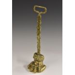 A 19th century brass doorstop, as a lion paw, posted loop handle, lead weighted base,