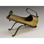 A French wrought iron and brass wine bottle pouring cradle, by Jean Goardere, signed, scroll lehs,