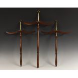 A set of three Edwardian gentleman's mahogany hangers, brass hooks, arched arms, turned poles,