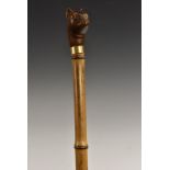 An early 20th century novelty walking cane handle, carved as the head of a cat, glass eyes,
