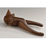 A Black Forest novelty lever-action nut cracker, carved as a gentleman wearing a nightcap,