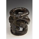 An African coromandel stool, carved as a coiled snake, the side with lizards and elephants, 24.