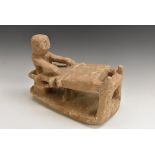 A South American figural model, of a figure at a loom, 34cm wide,