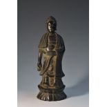 Chinese School, a dark patinated bronze, Buddha, standing upon a lotus,