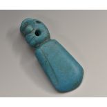 A turquoise pendant, possibly Maori, carved with a stylised mask,