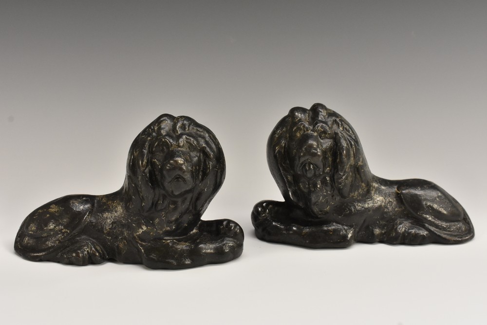 A pair of George III cast iron desk weights or door stops, cast as recumbent lions,