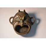 A Continental brown patinated bronze novelty incense burner, as a horned Devil mask,