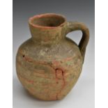 An English Medieval terracotta ovoid ale jug, 21.5cm high, c.