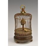 A brass novelty automaton table clock, as a bird in a cage,