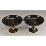 A pair of 19th century dark patinated bronze tazzas, each centred by a profile portrait roundel,