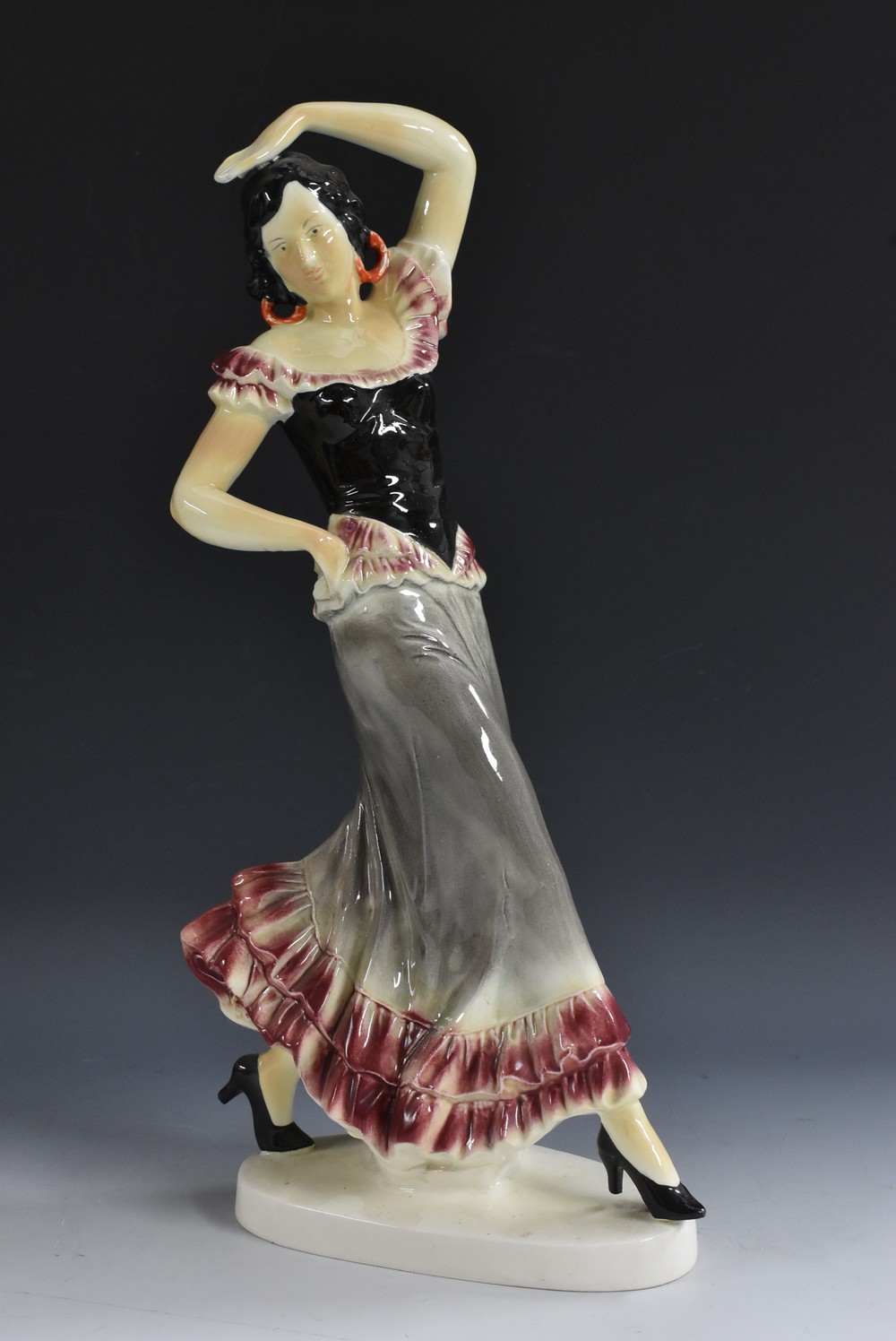 A large continental earthenware model of a Flamenco Dancer, glazed in glossy tones of pink, grey,