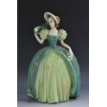 A Goebel model of a fashionable lady, she stands in green poke bonnet and dress holding a purse,