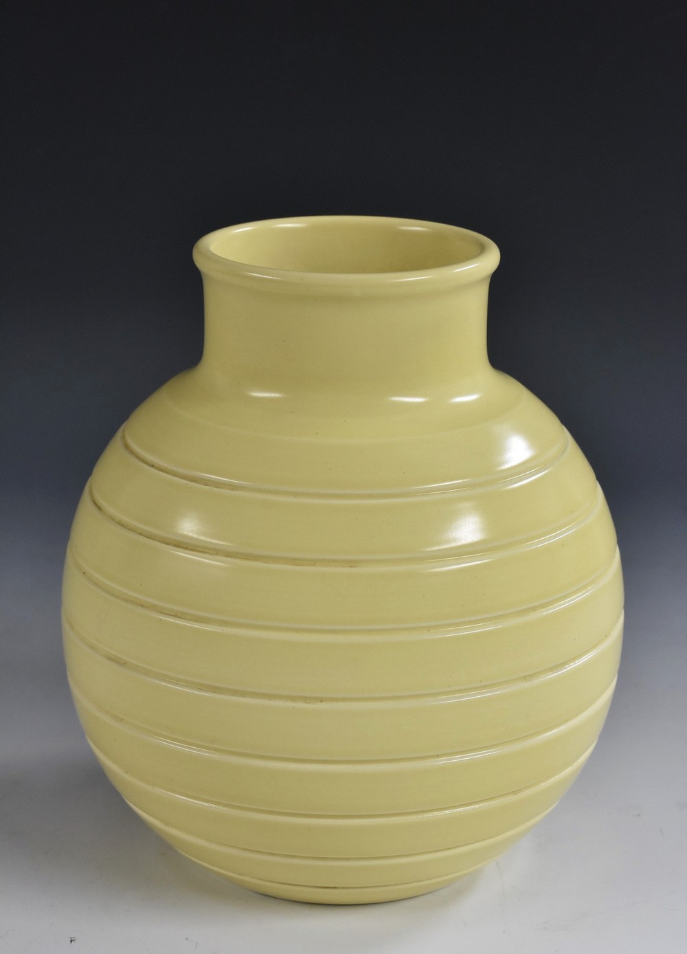 A Keith Murray for Wedgewood globular vase, incised linear decoration, pastel yellow glaze,