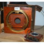 An early 20th century ttriple Victo folding full plate camera, slides, lens adaptor, hood, etc,