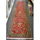 A hand woven middle eastern Tabris runner, floral decoration in hues of green,