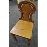 An early 19th century mahogany hall chair, shaped and pierced back, wooden seat,
