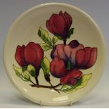 A Moorcroft Clematis pattern plate, tube lined with large flowerhead and foliage,