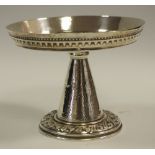 An arts and crafts coloured metal tazza, conical column, framed ebonised base.