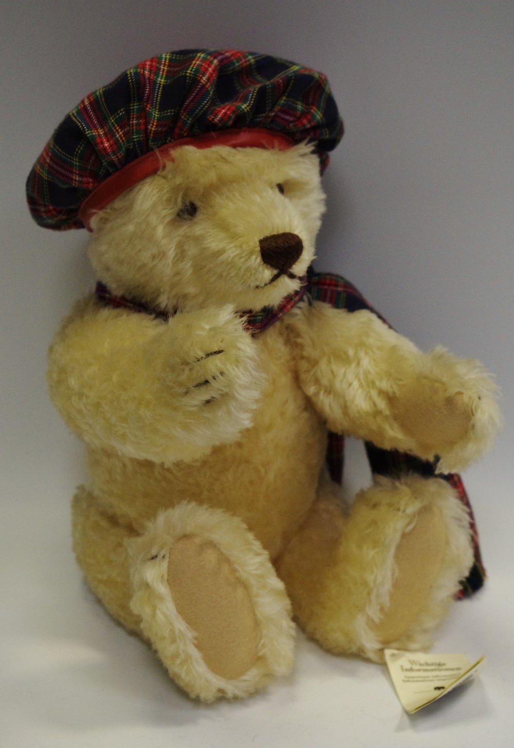 A Steiff teddy bear, with 'growling' mechanism, tartan dress,