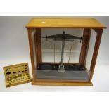 A set of scientific balance scales, cased with cased weights.