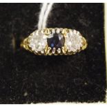 An 18ct gold trilogy ring, set with a central sapphire and two diamonds approx, 4.3g.