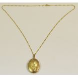 A 9ct Gold oval locket, engraved and chased with foliage, a 9ct gold figero necklace,