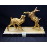 An Art Deco style study of two goats, one rearing, in gilt metal on a rectangular onyx base,