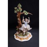 An Italian model of a girl on a swing, 27cm,