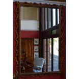 A Rococo style wall mirror, the rectangular frame applied with scrolling foliage, rope-twist border,