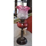A Victorian Cranberry and clear glass oil lamp, Cranberry reservoir etched shade, gilt metal column,