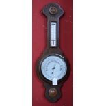 A carved oak aneroid barometer thermometer, carved top and foot, silvered scale,