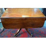 A George III mahogany dropleaf dining table, turned column, sabre legs, brass capped casters,