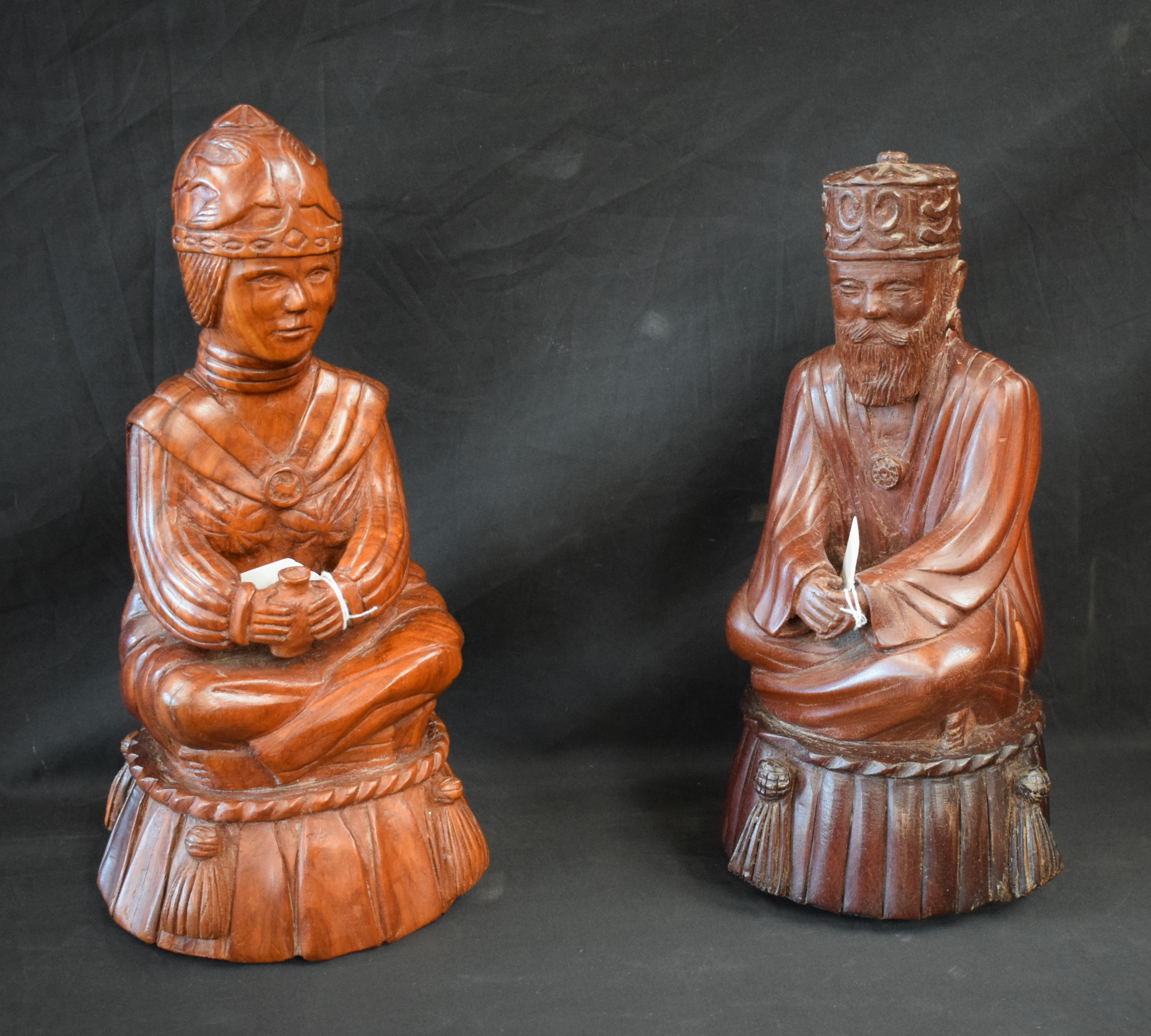 Tribal Art - a pair of carved wooden figures, Emperor and Empress, seated cross legged,