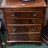 A reproduction mahogany chest of four long graduated cockbeaded drawers below a slide,